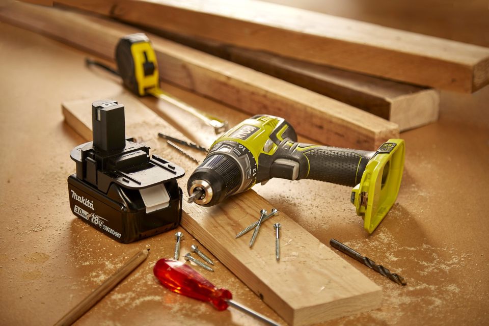 Makita battery and Ryobi drill on workstation surrounded by woodworking paraphernalia