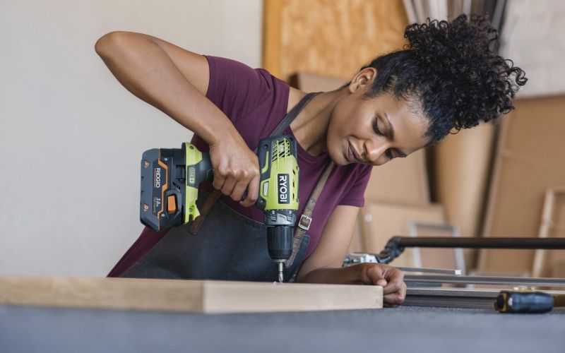 Woman doing DIY with Ryobi drill