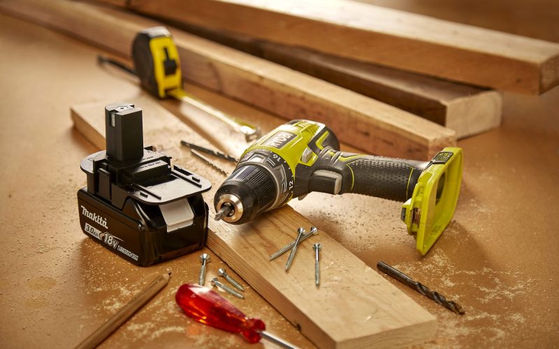 Makita battery and Ryobi drill on workstation surrounded by woodworking paraphernalia