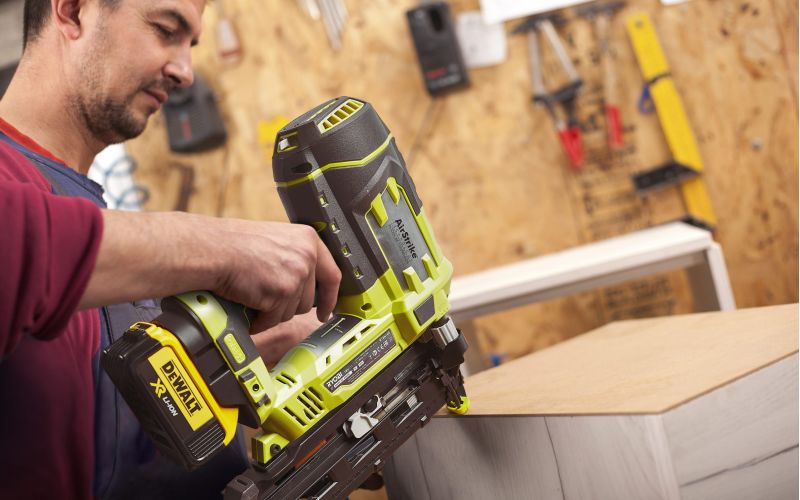 Man using Ryobi cordless nail gun to attach drawer back panel