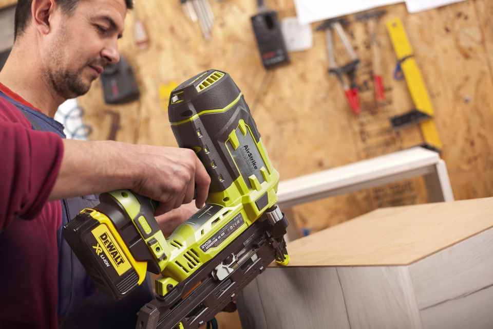 Man using Ryobi cordless nail gun to attach drawer back panel
