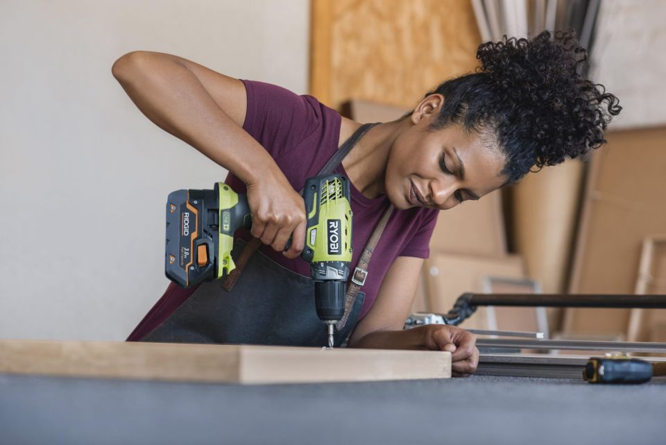 Woman doing DIY with Ryobi drill