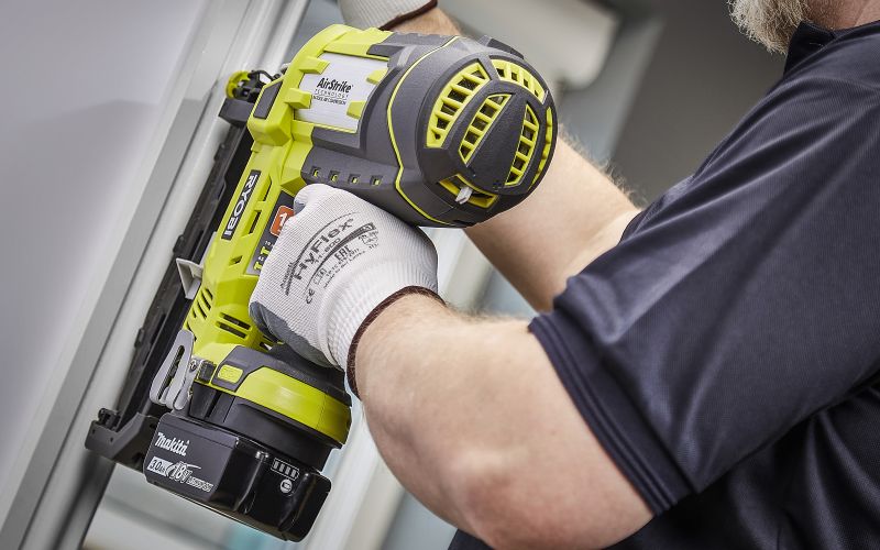 Man repairing door frame with Ryobi Nail gun